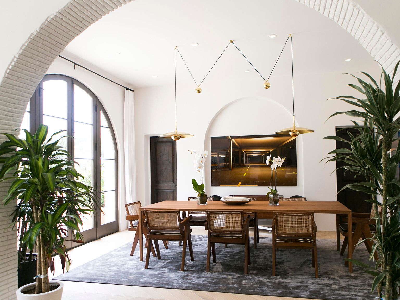 Primary suite with vaulted ceiling and arched window framing the mountain view